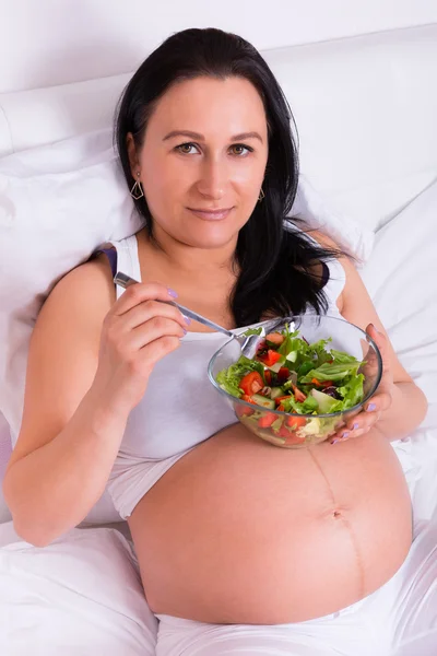 Pregnant woman eating fresh salad