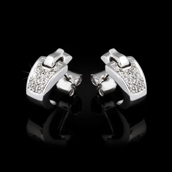 White gold earrings isolated on the black background