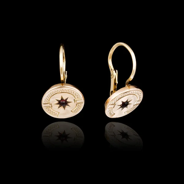 Gold earrings isolated on black background