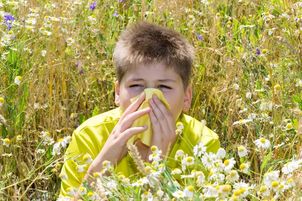 Boy with allergic rhinitis in meadow