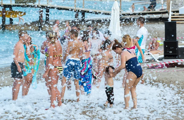 Kemer, Turkey-August 21, 2014. Foam Party on resort. Group of people enjoying in drinking, dancing and music.
