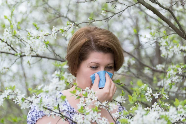 Woman with allergic rhinitis in  spring garden