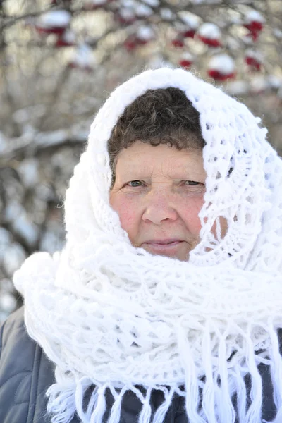 Elderly woman in  white knitted shawl costs about Rowan