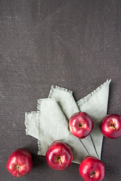 Five red apples on a painted board