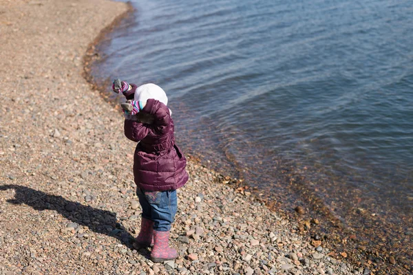 Girl throwing stones into the river