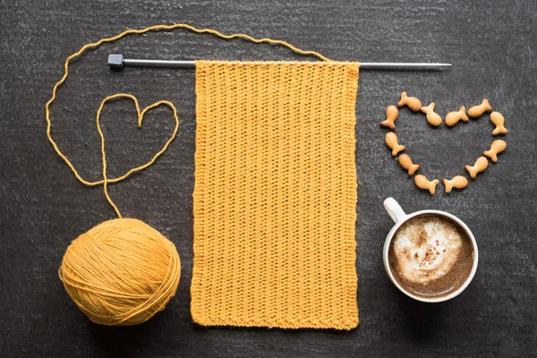 Knitting, cup of coffee and fish crackers heart