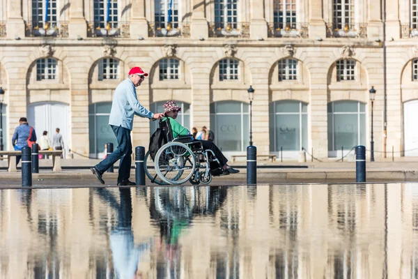 People visiting a mirror fountain in Bordeaux, France