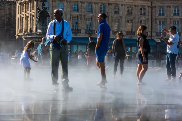 People having fun in a mirror fountain