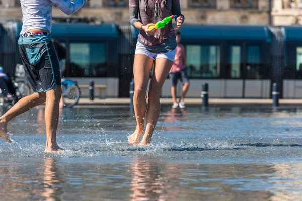 People having fun in a mirror fountain