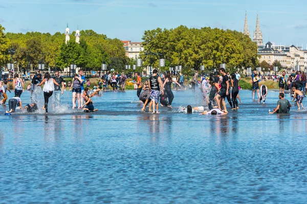 People having fun in a mirror fountain