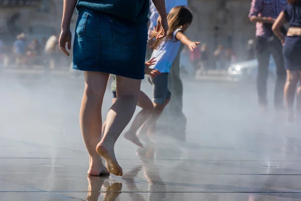 People having fun in a mirror fountain