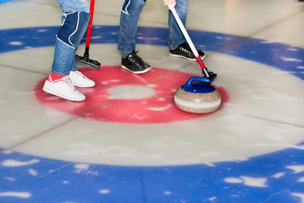 Players curling stones on the ice