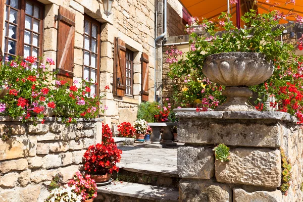 Bright flower pots on an ancient stone house in France