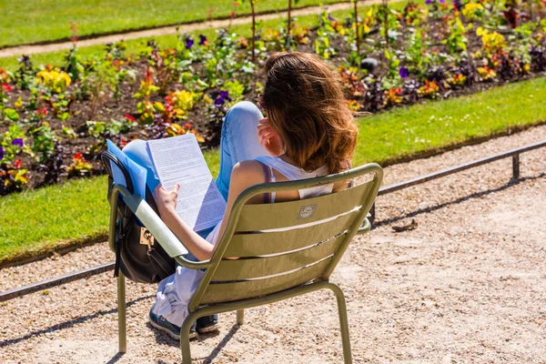 Young girl reading a book in the park