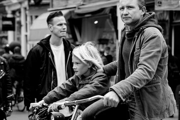 AMSTERDAM, NETHERLANDS - MAY 9:  Father with son riding bicycles in historical part in Amsterdam, Netherlands on May 9, 2015