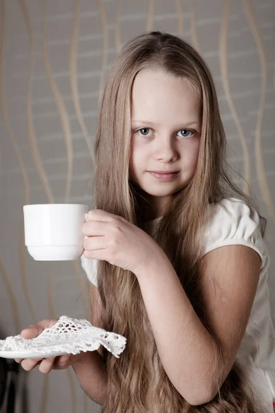 Blonde cute girl holding a cup of tea