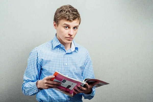 Young man reading a magazine