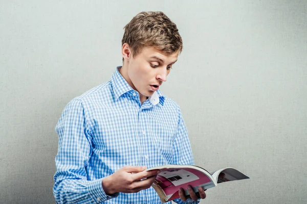 Young man reading a magazine