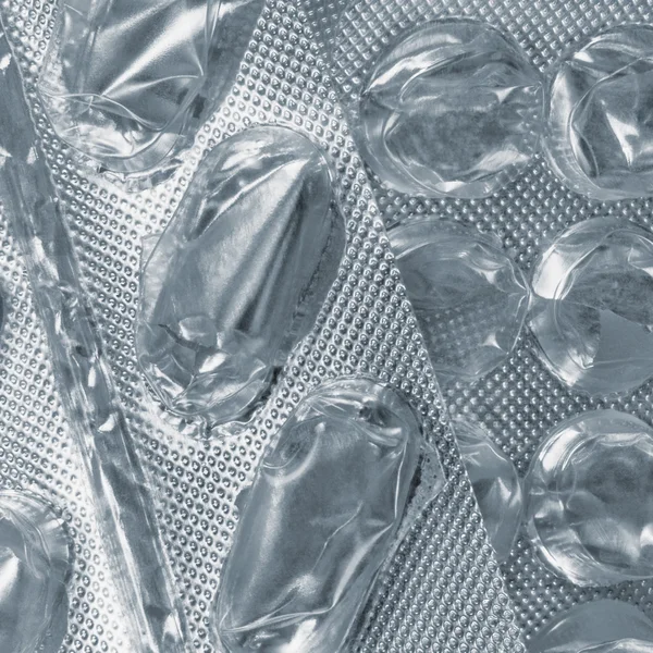 Empty pill blister background, multiple emptied tablet blisters silver texture pattern close-up, large detailed vertical textured macro closeup