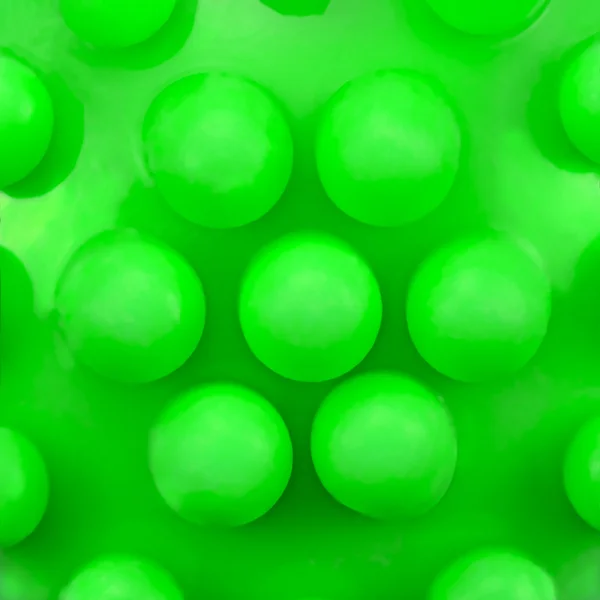 Dog teeth massage toy ball knobs pattern, large deailed green macro closeup, abstract plastic circles texture studio shot, canine dental care concept