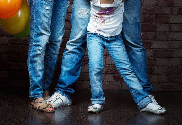 A young family wearing jeans