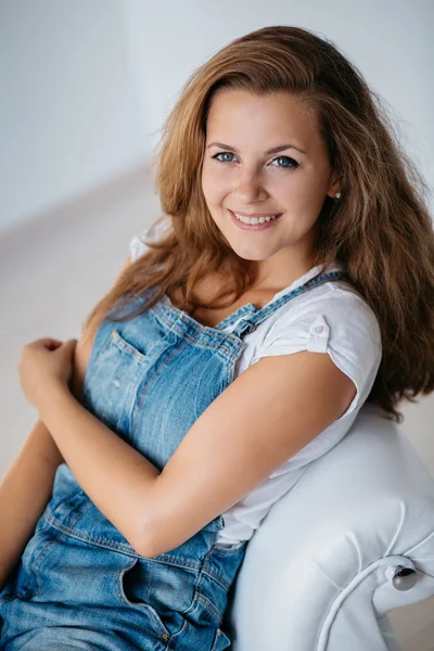 Studio portrait of an attractive young woman in jeans overalls