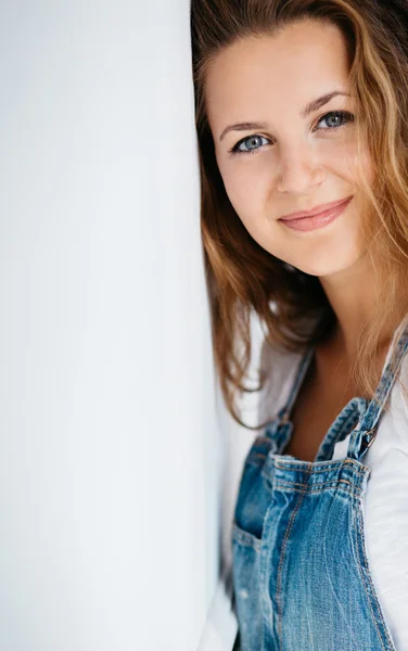 Studio portrait of an attractive young woman in jeans overalls