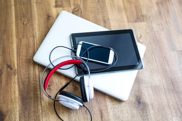 Digital devices and Headphones on a wooden Desktop