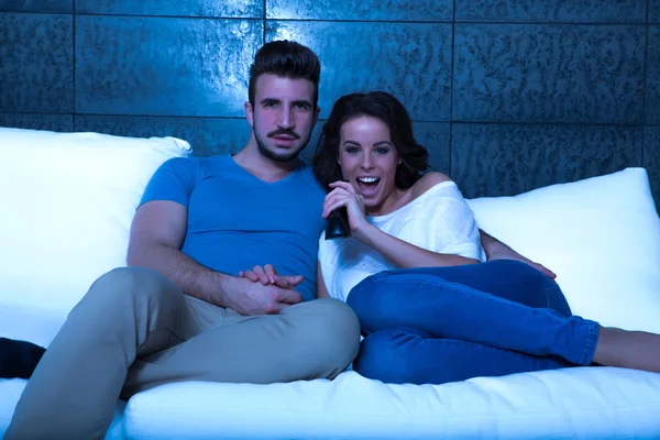 Young couple watching TV together on the Sofa