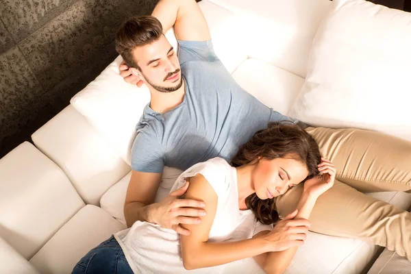 Young couple cuddling on the sofa at home