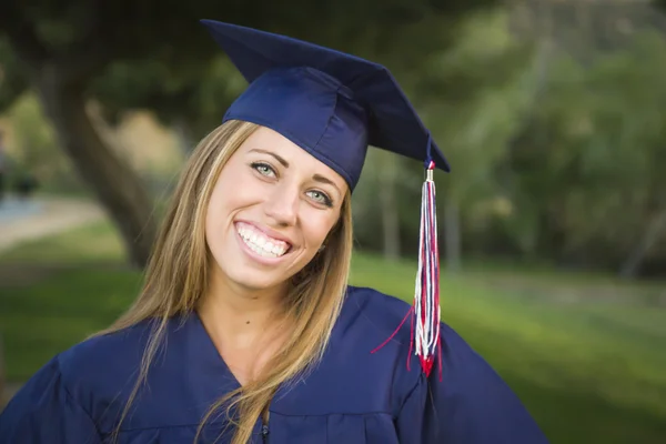 Young Woman Wearing Cap and Gown Outdoors