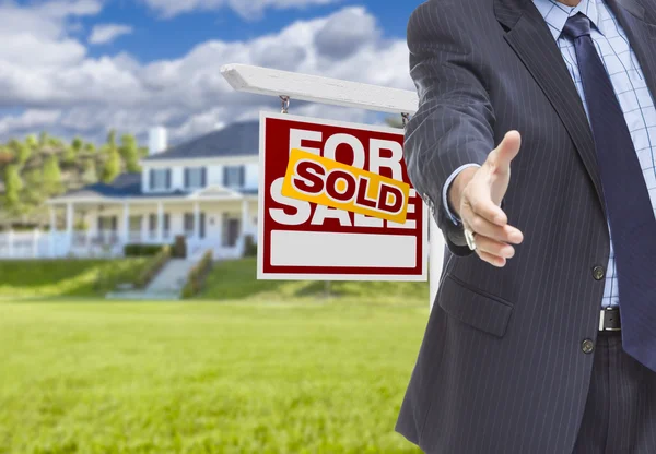 Agent Reaches for Handshake, Sold Sign and House Behind