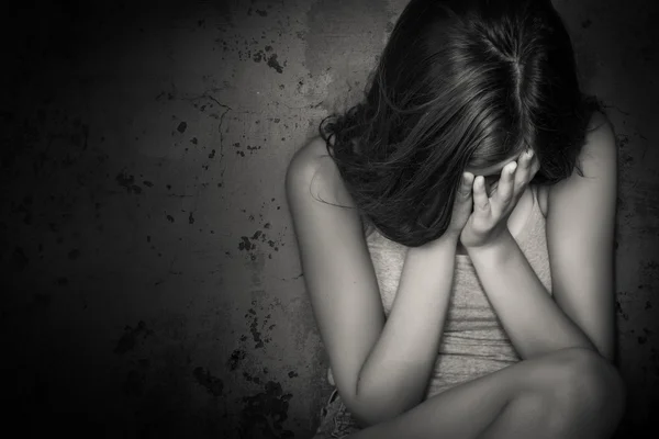 Black and white grunge image of a teen girl crying