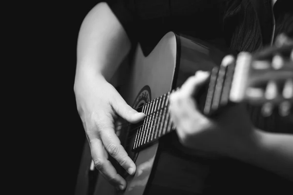 Hands playing a classic guitar