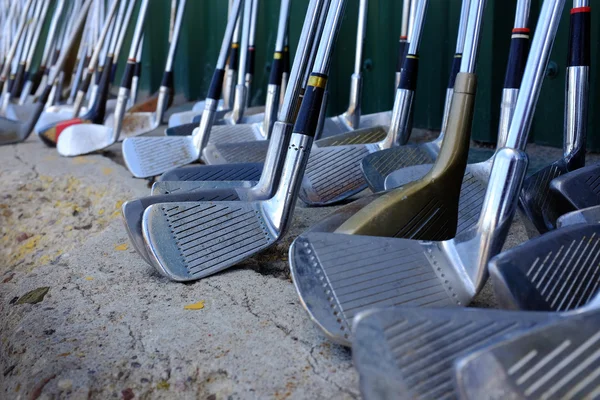 Row of Many Old Used Golf Clubs for Sport