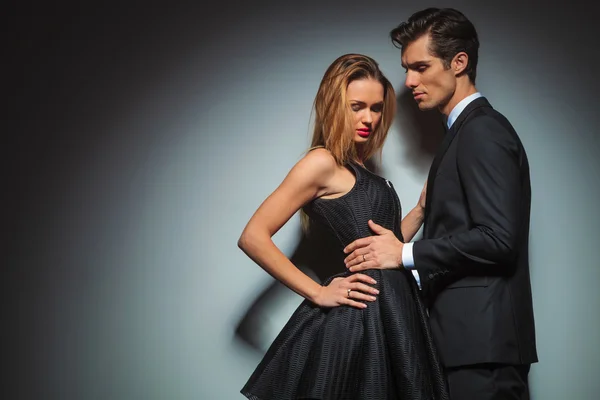 Couple in black posing embraced in studio