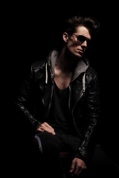 Side view of dramatic young man in leather jacket