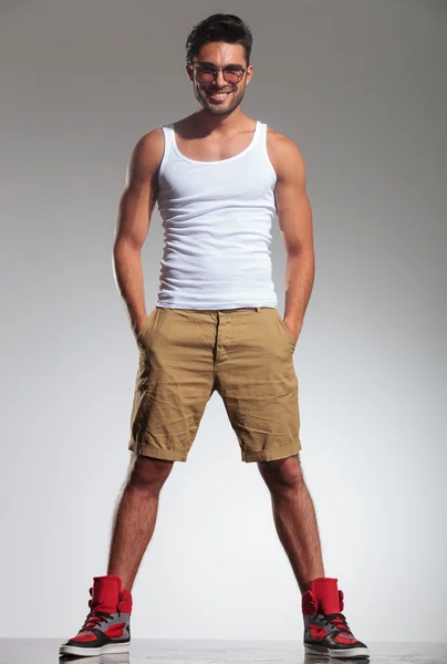 Man in undershirt and shorts smiling