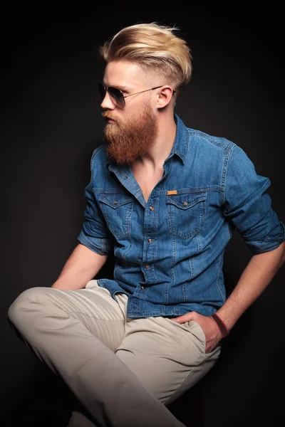 Red beard man sitting with his hand in the pocket