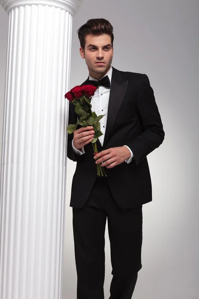 Business man holding bouquet of red roses in his hand