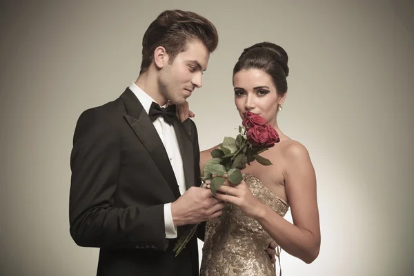 Young man giving his wife a bunch of red roses