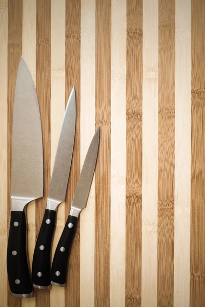 Set of three professional cooking knives on cutting board