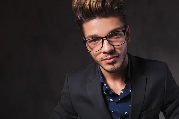 Fashionable smart man wearing glasses in dark studio