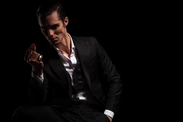 Model in tuxedo snaps his fingers in dark studio