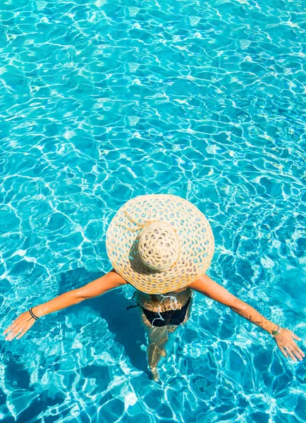 Woman with hat at the pool