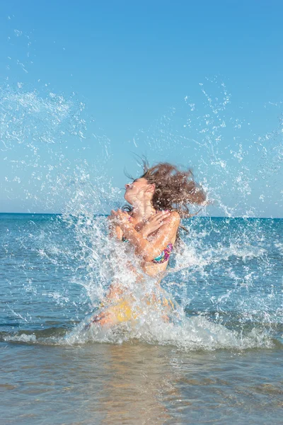 Beauty Model Girl Splashing Water in the ocean