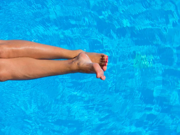 Legs of woman lying near the pool . Beautiful female a foot