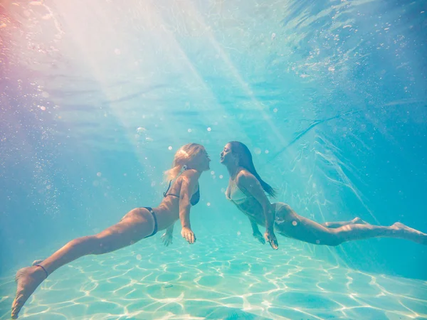 Two young women swimming underwater