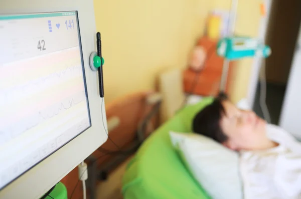 Patient in hospital room with screening monitor