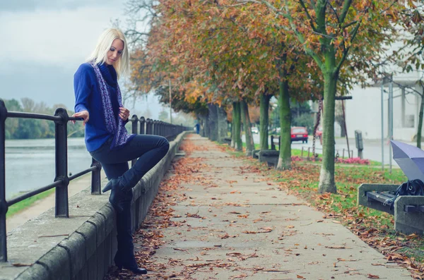 Beautiful young woman outdoor on rainy autumn day